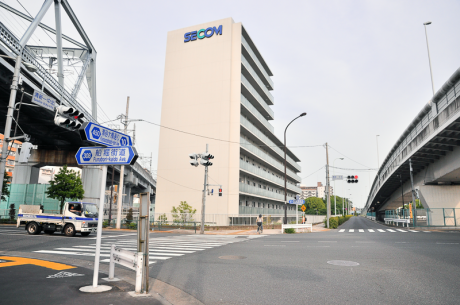 清新一中北交差点から東側をながめたところ。写真中央下から右上に伸びる歩道と同じ位置に、東西線ができた頃の海岸線があった。