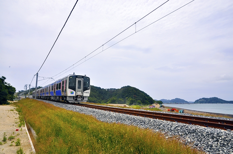 仙石線 東名-陸前大塚間の新線切り替え地点付近を走るHB-E210系気動車。旧線は右の海岸線沿いに通っていた。