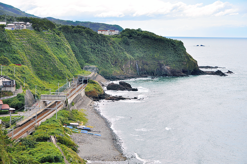 駅北東側の丘の上から眺めた青海川駅。写真左下の小さなアーチ橋は旧線跡の橋台に架けられた遊歩道の橋。