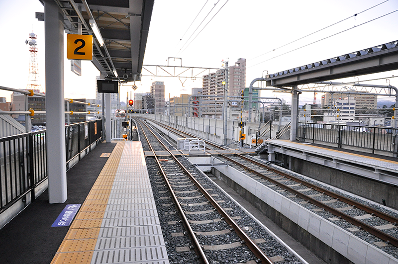 新福井駅から南側仮福井駅方向の眺め。防音壁の内側にプラットホームが収まってしまうという、新幹線と私鉄線の車格の違いに驚かされる。この踏切は、いずれ新幹線が開通したあかつきには「ここに踏切があった」という伝説の場所になるかもしれない。