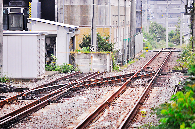 左は入生田駅2番線側 風祭駅方にある安全側線の3線軌条の分岐器で、直線側が開通している状態。1,067mmゲージの車輪はトングレール、可動クロッシング、固定クロッシング2つの順に通ってゆくため、こちらは3線分岐器らしい通過音が聴ける。