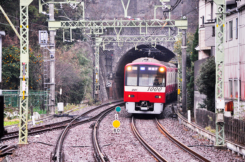 神武寺駅の六浦駅方にある3線軌条の分岐器。1,435mmゲージと1,067mmゲージとの、それも共通レール側への分岐のため、とてもシンプルな構造になっている。ところで、海峡線共用区間の3線軌条は、YOUTUBEにアップされている後方展望で視たところによると上下線ともに共通レールが外側に敷設されており、3線軌条区間の終始点である新中小国信号場と木古内駅では在来線が新幹線の外側から合流分岐する構造、そして中間の奥津軽いまべつ駅では新幹線駅の外側を在来線が通る形態を採っているため、そこの合流側にはこれと同じ構造の分岐器(海峡線共用区間の方はクロッシングがノーズ可動だが)が使用されている。