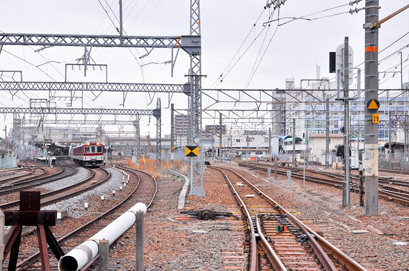 踏切の中洲から北向き桑名駅方の眺め。左が1,435mmゲージの近鉄名古屋線で車輛は2444系2444F、右が1,067mmゲージのJR関西本線。そして右端に見えるプラットホームは762mmゲージの西桑名駅だ。