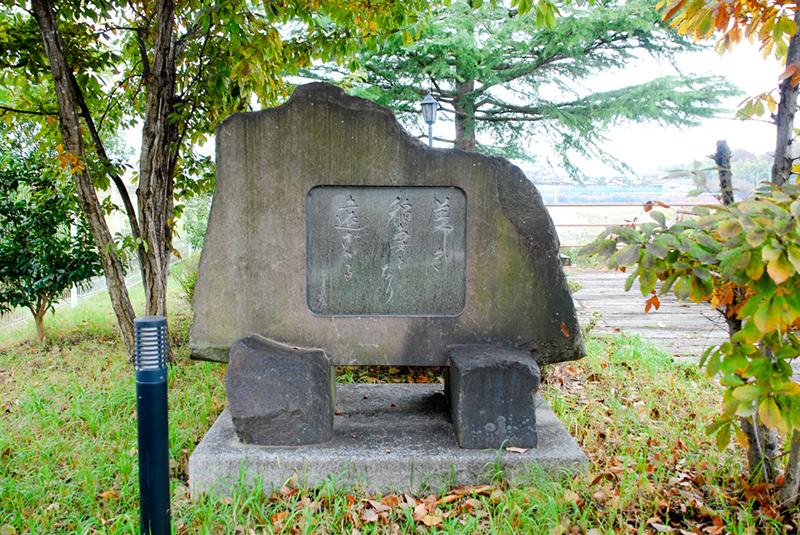 “路傍の石”の石碑の向かって左岸にある石碑。碑文は「美しく　稲妻となり　遠ざかる」と刻まれている。
