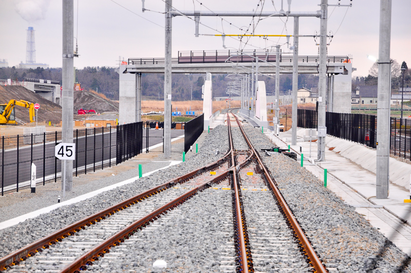 新地駅の駒ヶ嶺寄りからの南方の眺め。駅の高さは低いが、左に道路を兼ねた土塁が築かれているのが解る。