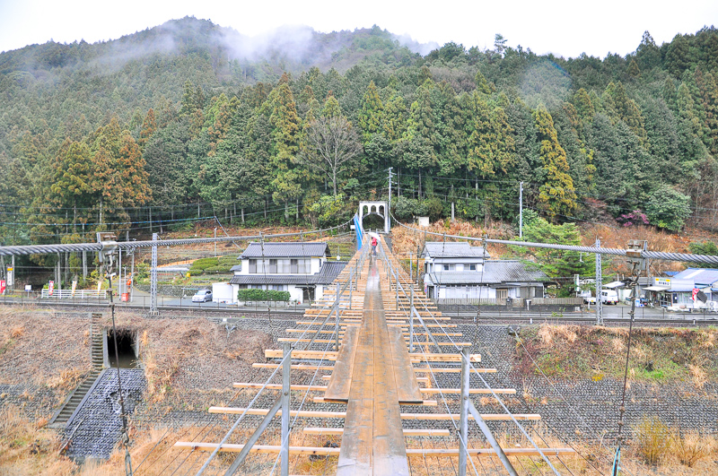 吊り橋を1/3程渡ったあたりからの東岸の眺め。橋と線路と川岸の関係はこんな感じ。ちなみに歩み板が幅広になっている場所で対向者とすれ違うことができる。