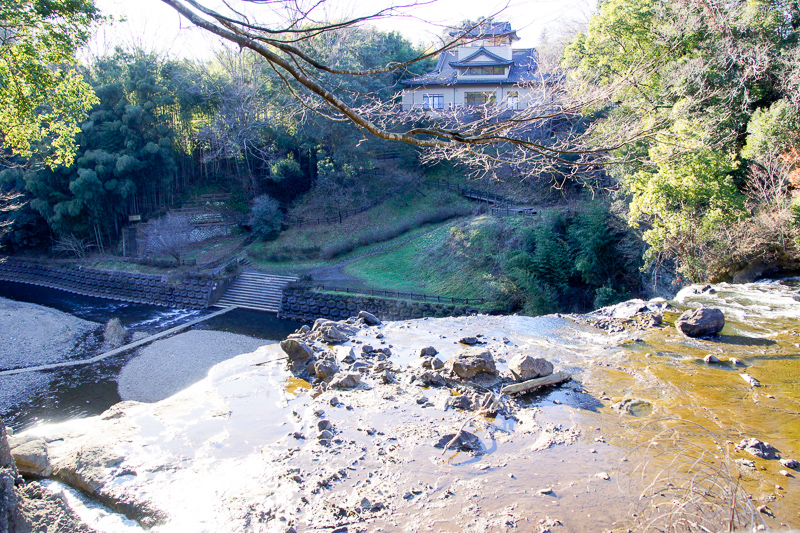 滝口を、上に通っている道路の歩道から眺めたところ。烏山線からもこれとほぼ同じように見えるが、夏になると樹木に葉が繁るので、全貌を見るには辛くなってしまう。ちなみに写真の上方にあるのが「龍門ふるさと民芸館」だ。